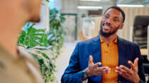 Employee having a positive conversation in office with plants in the background, representing sustainability and environmental awareness at work