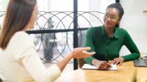 Two colleagues in conversation at work, reflecting the role of communication in creating safer, more respectful workplaces.
